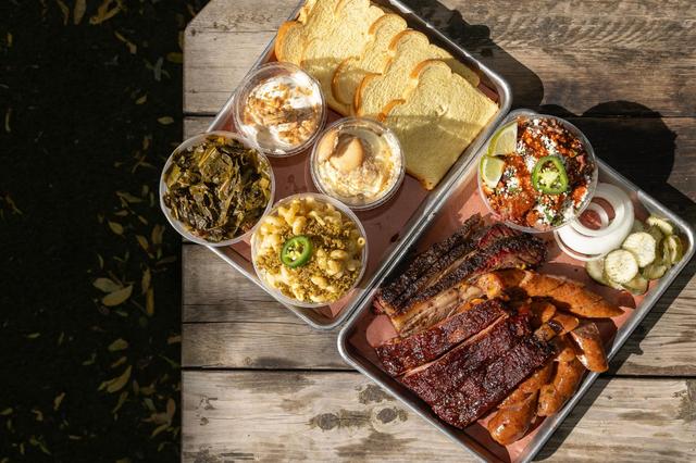 A platter with brisket, pork spare ribs, jalapeño cheese sausage, and a brisket eloté cup are paired with sides of collard greens, spicy smoked Mac & Cheese, banana pudding, and sliced bread at Panther City BBQ in Fort Worth. Panther City BBQ landed a spot on the Michelin recommended list making it one of the three restaurants Fort Worth to make the prestigious catalog.